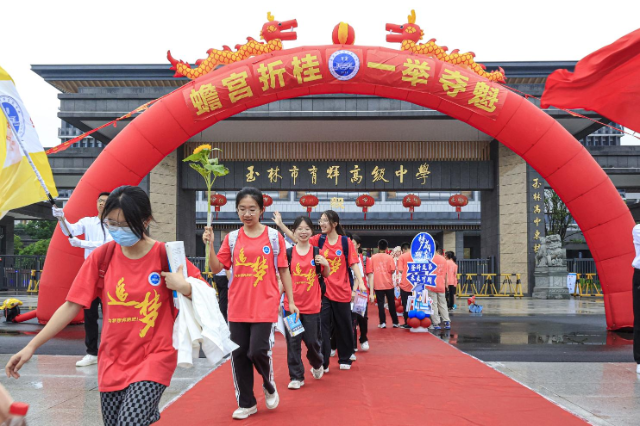 玉林市育輝高級中學(xué)紅毯鋪地，紅聯(lián)掛樓，為勇士出征高考助威祝福。在一片助威聲中，育園學(xué)子目光如炬，步伐堅(jiān)定，意氣風(fēng)發(fā)地邁過狀元門，斗志昂揚(yáng)地出征高考。（陳穎強(qiáng)  周家名）.png