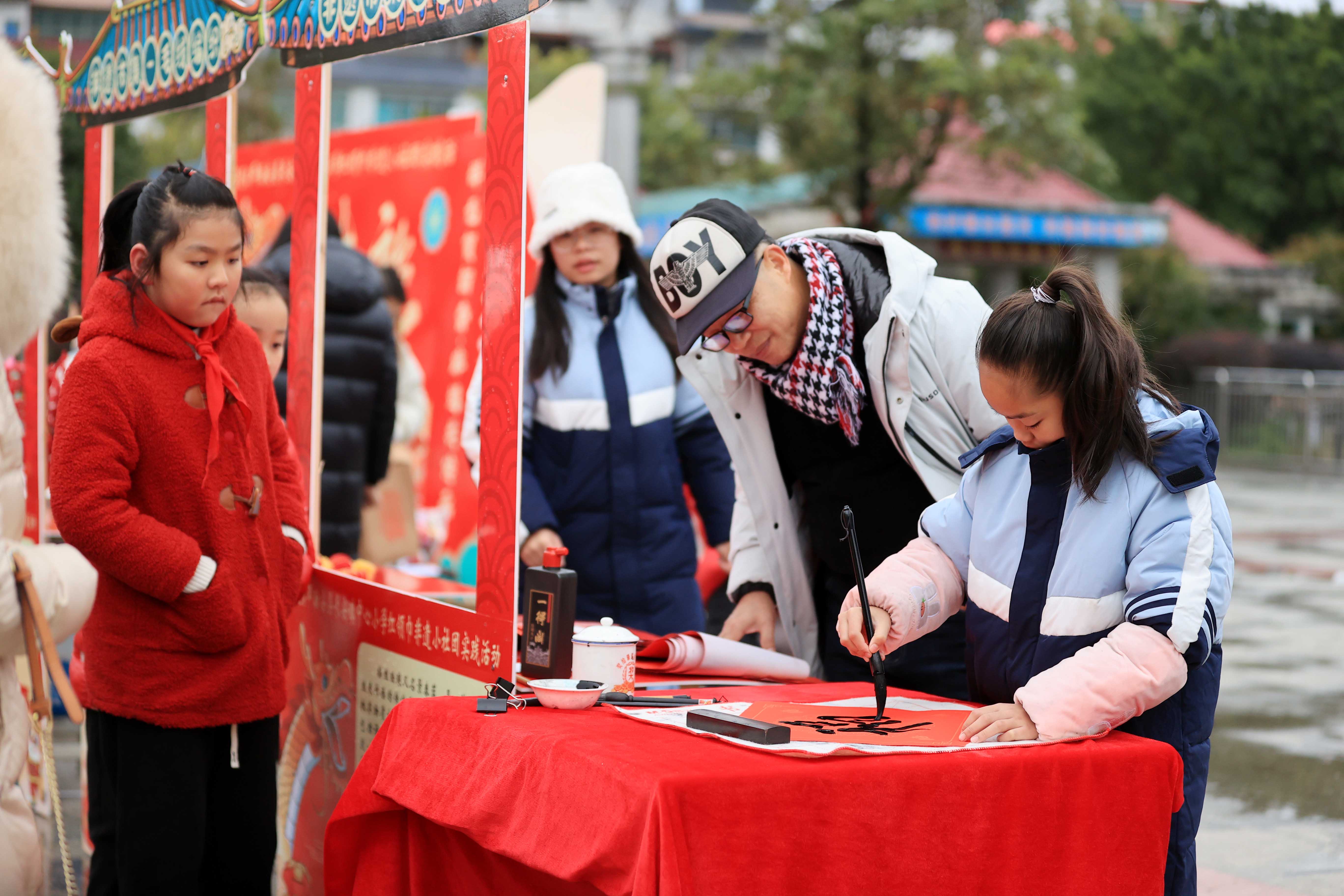 圖10：1月20日，在廣西柳州市融安縣長安廣場，一名小學生在書寫福字，準備贈送市民。（譚凱興 攝）.JPG